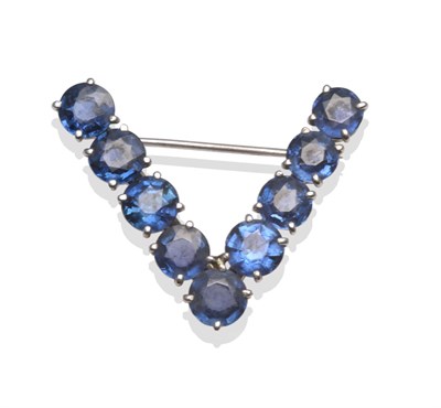 Lot 218 - A Sapphire Set Brooch, round mixed cut blue sapphires, forming the initial 'V', measures 3.5cm...
