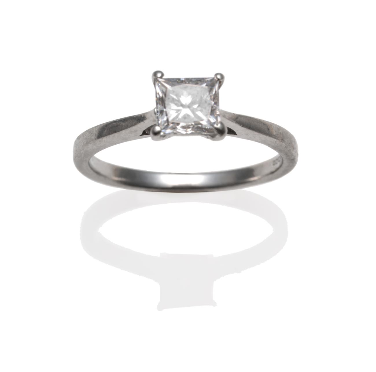 Lot 219 - A Platinum Diamond Solitaire Ring, the princess cut diamond in a claw setting on a tapered shoulder