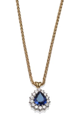 Lot 222 - An 18 Carat Gold Sapphire and Diamond Pendant on Chain, the pear cut sapphire within a border...
