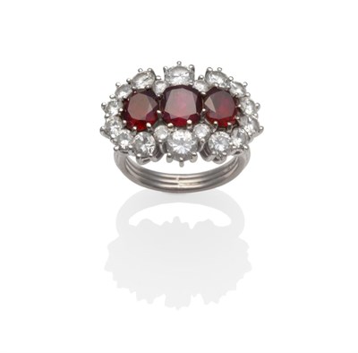 Lot 235 - A Ruby and Diamond Triple Cluster Ring, three oval mixed cut rubies within a border of round...