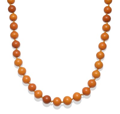 Lot 252 - An Amber Necklace, fifty-nine off-round butterscotch coloured beads knotted in one continuous...