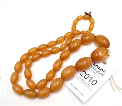 Lot 2010 - A String of Forty Rhinoceros Horn Turned Oval Section Beads, circa 1930, of honey colour, 66cm...