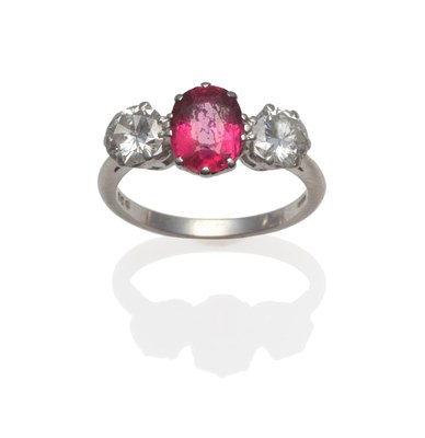 Lot 260 - A Platinum Ruby and Diamond Three Stone Ring, an oval mixed cut ruby within two round brilliant cut
