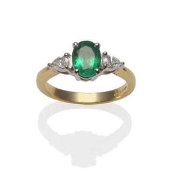 Lot 286 - An 18 Carat Gold Emerald and Diamond Three Stone Ring, an oval mixed cut emerald within two...