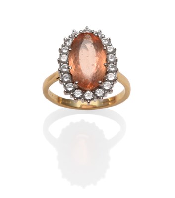 Lot 311 - An 18 Carat Gold Topaz and Diamond Cluster Ring, the oval cut pinky-orange topaz within a border of