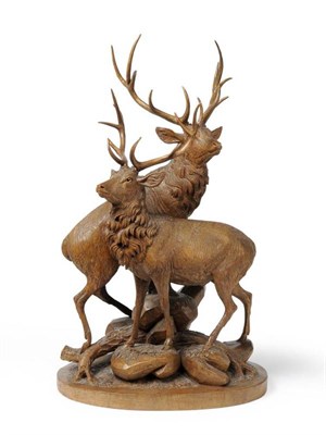 Lot 1299 - A Swiss Carved Limewood Group of Two Stags, Brienz, circa 1900, both stood amongst boulders and...