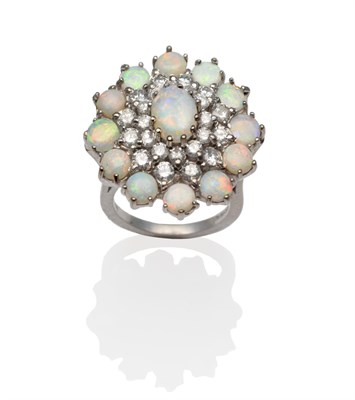 Lot 322 - An 18 Carat White Gold Opal and Diamond Cluster Ring, an oval cabochon opal within a double...