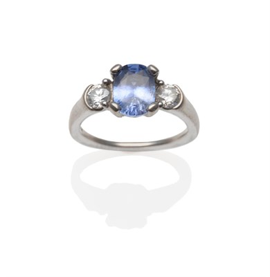 Lot 338 - An 18 Carat White Gold Sapphire and Diamond Three Stone Ring, an oval cut blue-purple sapphire...
