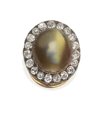 Lot 345 - A Cat's-Eye Chrysoberyl and Diamond Cluster Clip, the oval cabochon cat's-eye in yellow claws,...
