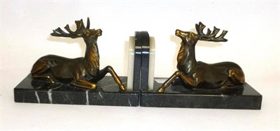 Lot 76 - A Pair of Bookends Modelled as Stags on Marble Bases, the recumbent bronzed spelter stags on veined