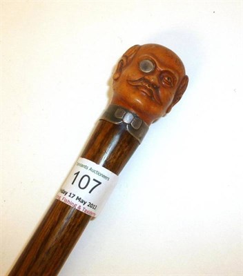 Lot 107 - A Novelty Walking Cane, the boxwood handle carved as a monocled and mustachioed gentleman, with bow