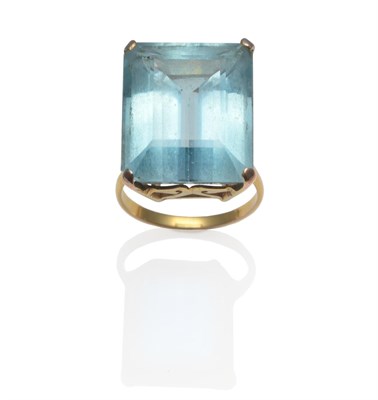 Lot 353 - An Aquamarine Ring, the emerald-cut aquamarine in a yellow four claw setting on a plain...