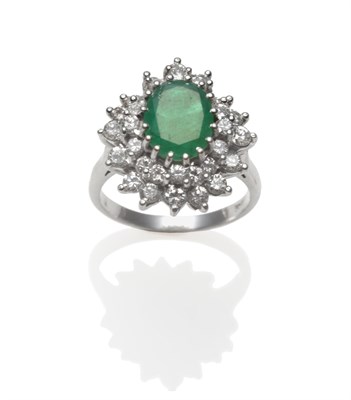 Lot 370 - An Emerald and Diamond Cluster Ring, an oval cut emerald within a double border of round...