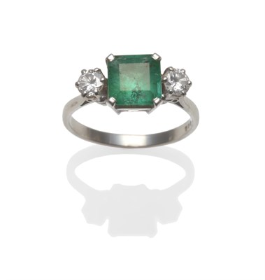 Lot 371 - A Platinum Emerald and Diamond Three Stone Ring, the emerald-cut emerald set between two round...