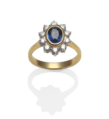 Lot 374 - An 18 Carat Gold Sapphire and Diamond Cluster Ring, the oval mixed cut sapphire in a yellow...
