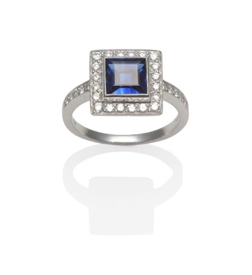 Lot 376 - An 18 Carat White Gold Sapphire and Diamond Cluster Ring, a square step cut sapphire within a...