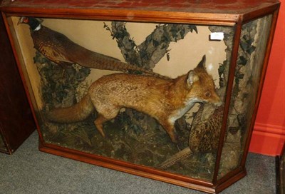 Lot 350 - A Taxidermy Group of a Fox and Cock and Hen Pheasant, circa 1900, the fox with dead hen pheasant in