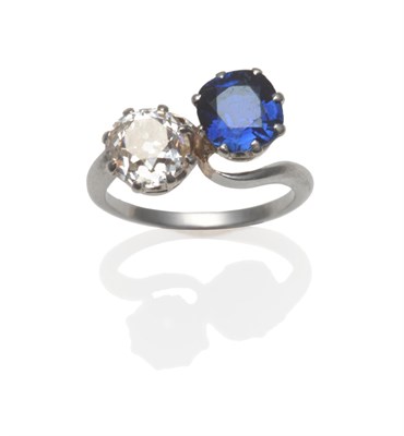 Lot 405 - A Sapphire and Diamond Twist Ring, a cushion cut sapphire and an old cut diamond in white claws...