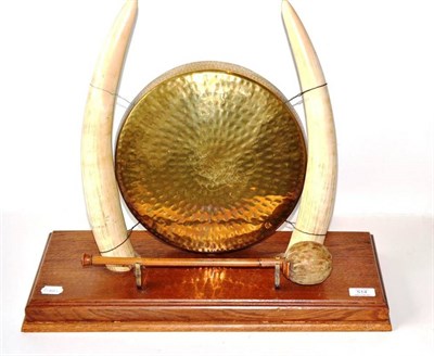 Lot 514 - An Elephant Tusk Mounted Dinner Gong, circa 1920, supporting a plannished brass circular gong,...