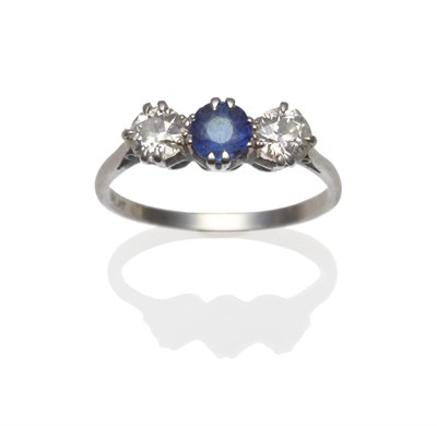 Lot 407 - A Sapphire and Diamond Three Stone Ring, a round mixed cut sapphire between two old cut...