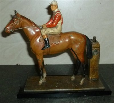 Lot 45 - A Spelter Horse and Jockey Strike-Lite Table Lighter, the bay horse with jockey in red and...