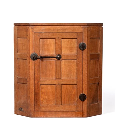 Lot 592 - A 1940's Robert  "Mouseman " Thompson Panelled Oak Hanging Corner Cupboard, opening to reveal...