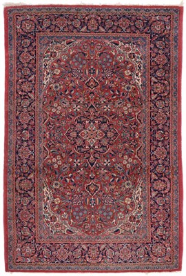 Lot 851 - Kashan Rug Central Persia The raspberry field of scrolling vines around an indigo medallion...