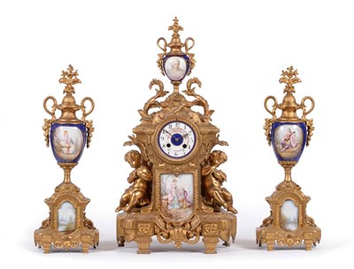 Lot 876 - A Gilt Metal and Porcelain Mounted Striking Mantel Clock Garniture, circa 1890, urn finial and...