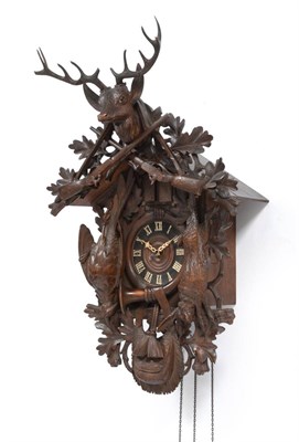 Lot 892 - A Black Forest Musical Cuckoo Clock, circa 1880, surmounted by a stags head and crossed rifles,...