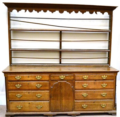 Lot 963 - A George III Oak Dresser, the associated rack with moulded cornice and shaped frieze over three...