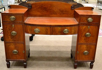 Lot 997 - A Regency Mahogany Sideboard, with a raised back over a sunk bowfront centre with two drawers,...