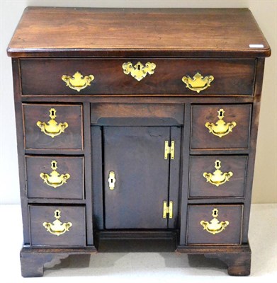 Lot 1011 - A George III Mahogany Kneehole Bureau-Table, with ovolo-moulded top over seven drawers about...