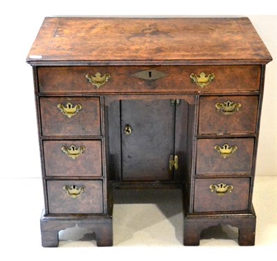 Lot 1015 - A George I Figured Walnut Bureau Table, with a quarter-veneered top over seven drawers about...