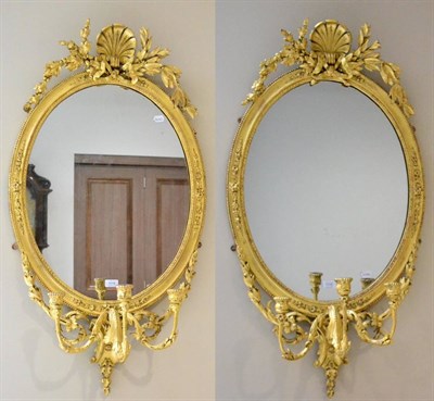 Lot 1016 - A Pair of Giltwood Girandoles, the oval plates within moulded frames with shell crestings, with...