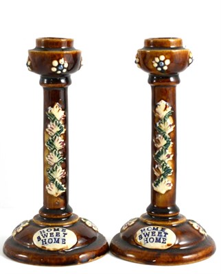 Lot 34 - A Pair of Measham Bargeware Candlesticks, circa 1880, inscribed HOME SWEET HOME on a foliate...
