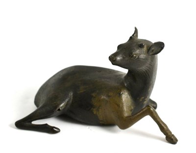 Lot 117 - A Chinese Bronze Figure of a Deer, in Ming style, the recumbent animal with a raised foreleg, bears