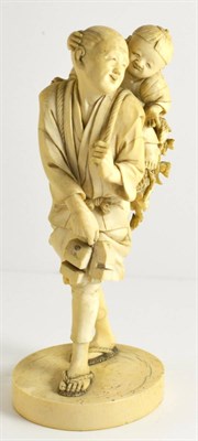 Lot 143 - A Japanese Ivory Okimono, Meiji period, of a man and child, he standing with a child riding on...