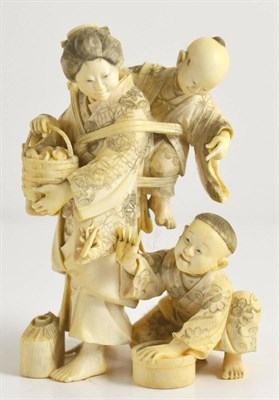 Lot 150 - A Japanese Ivory Okimono, Meiji period, as a mother and children, she holding a basket, one...