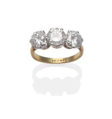 Lot 211 - A Diamond Three Stone Ring, the round brilliant cut diamonds in white claw settings, on a...