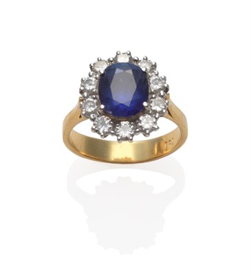 Lot 228 - A Sapphire and Diamond Cluster Ring, an oval mixed cut sapphire within a border of round...