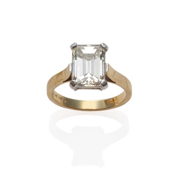 Lot 234 - A Diamond Solitaire Ring, the baguette cut diamond in a white four claw setting to a yellow...