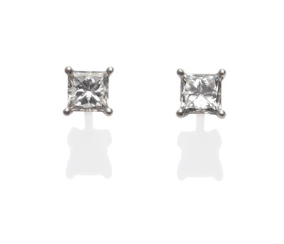 Lot 253 - A Pair of 18 Carat White Gold Princess Cut Diamond Solitaire Stud Earrings, the diamonds in...