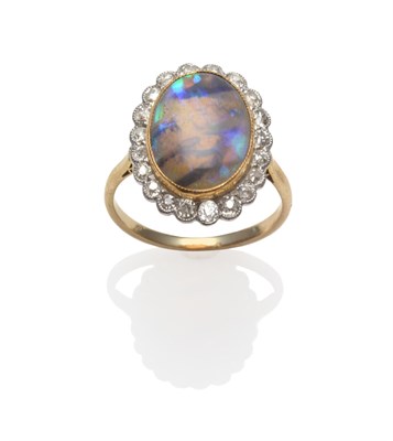 Lot 263 - A Black Opal and Diamond Cluster Ring, circa 1920, the oval black cabochon opal within a border...