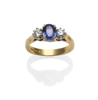 Lot 284 - An 18 Carat Gold Sapphire and Diamond Ring, an oval mixed cut sapphire between two round...