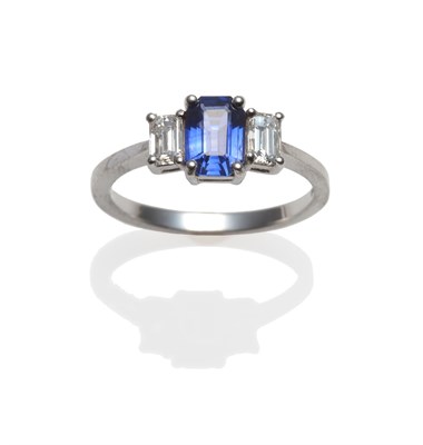 Lot 289 - A Platinum Sapphire and Diamond Three Stone Ring, the emerald-cut sapphire between two baguette cut