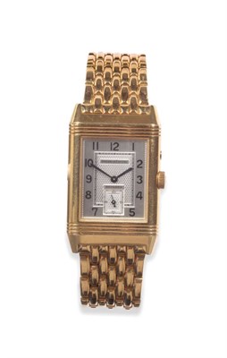 Lot 112 - An 18ct Gold Reversible Two Time Zone Indication Wristwatch, signed Jaeger LeCoultre, model:...