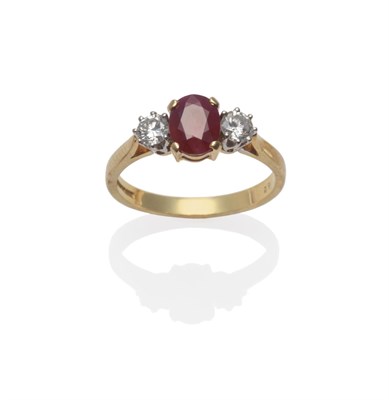 Lot 154 - An 18 Carat Gold Ruby and Diamond Three Stone Ring, the oval mixed cut ruby flanked by a round...