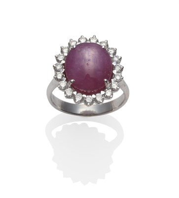 Lot 181 - An 18 Carat White Gold Star Ruby and Diamond Cluster Ring, an oval cabochon star ruby within a...