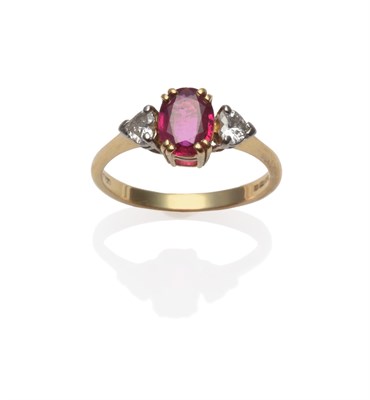 Lot 185 - An 18 Carat Gold Ruby and Diamond Three Stone Ring, the oval cut ruby in a yellow claw setting...