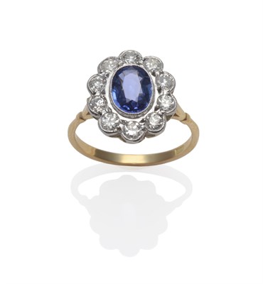 Lot 198 - A Sapphire and Diamond Cluster Ring, the oval mixed cut sapphire within a border of brilliant...